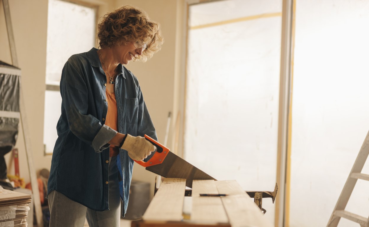 Person cutting wood with a handsaw