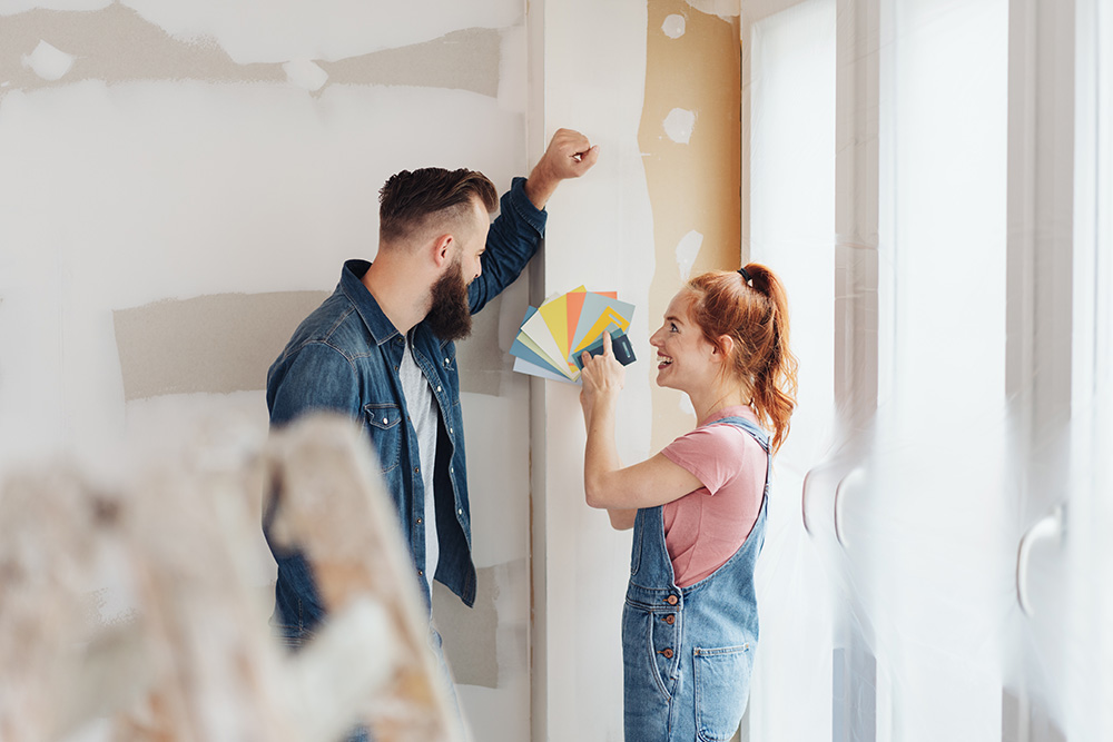 Two people deciding on a paint colour for their wall