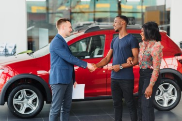 Couple purchasing a new red car