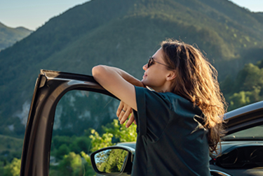 Person looking out into the distance at a forested mountain view