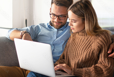 Couple sat looking at a laptop