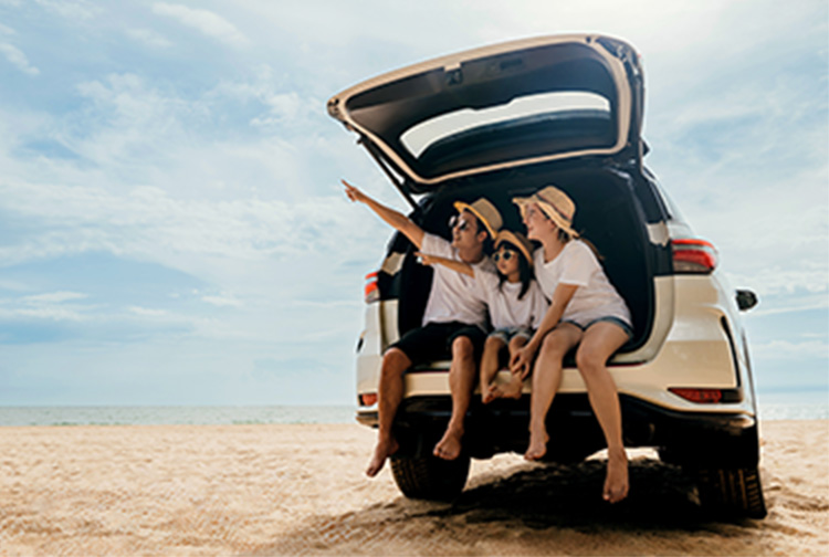 People sat in a car while on a sandy beach